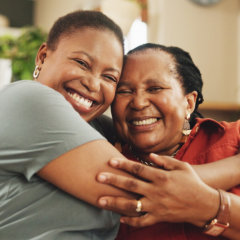 Two people embracing warmly on a couch, conveying comfort and support in a cozy living room